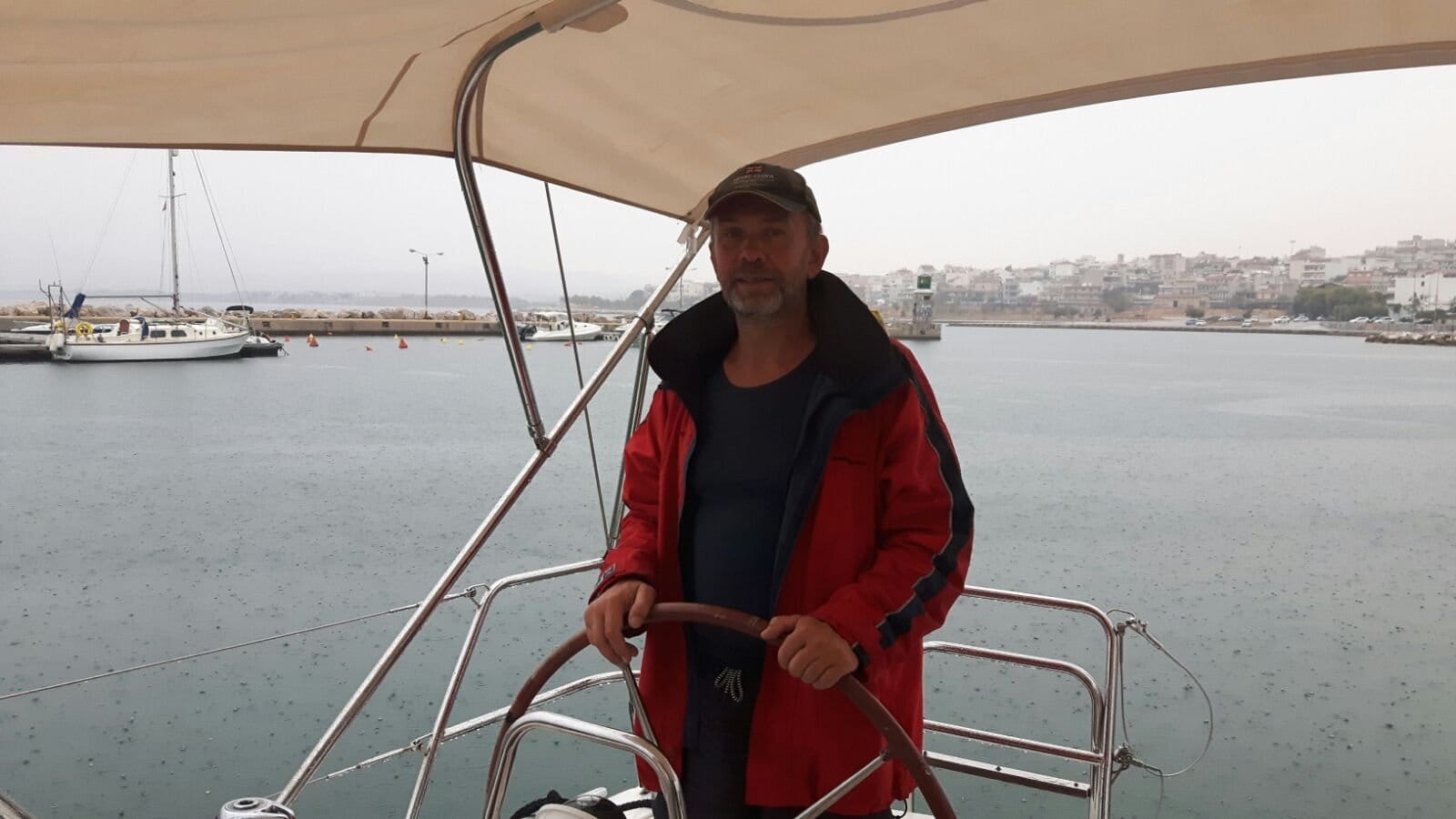 Skipper at the helm of the Oceanis 40 arriving in a Greek harbour on the delivery from Koper to Lavrio Skipper at the helm of the Oceanis 40 arriving in a Greek harbour on the delivery from Koper to Lavrio