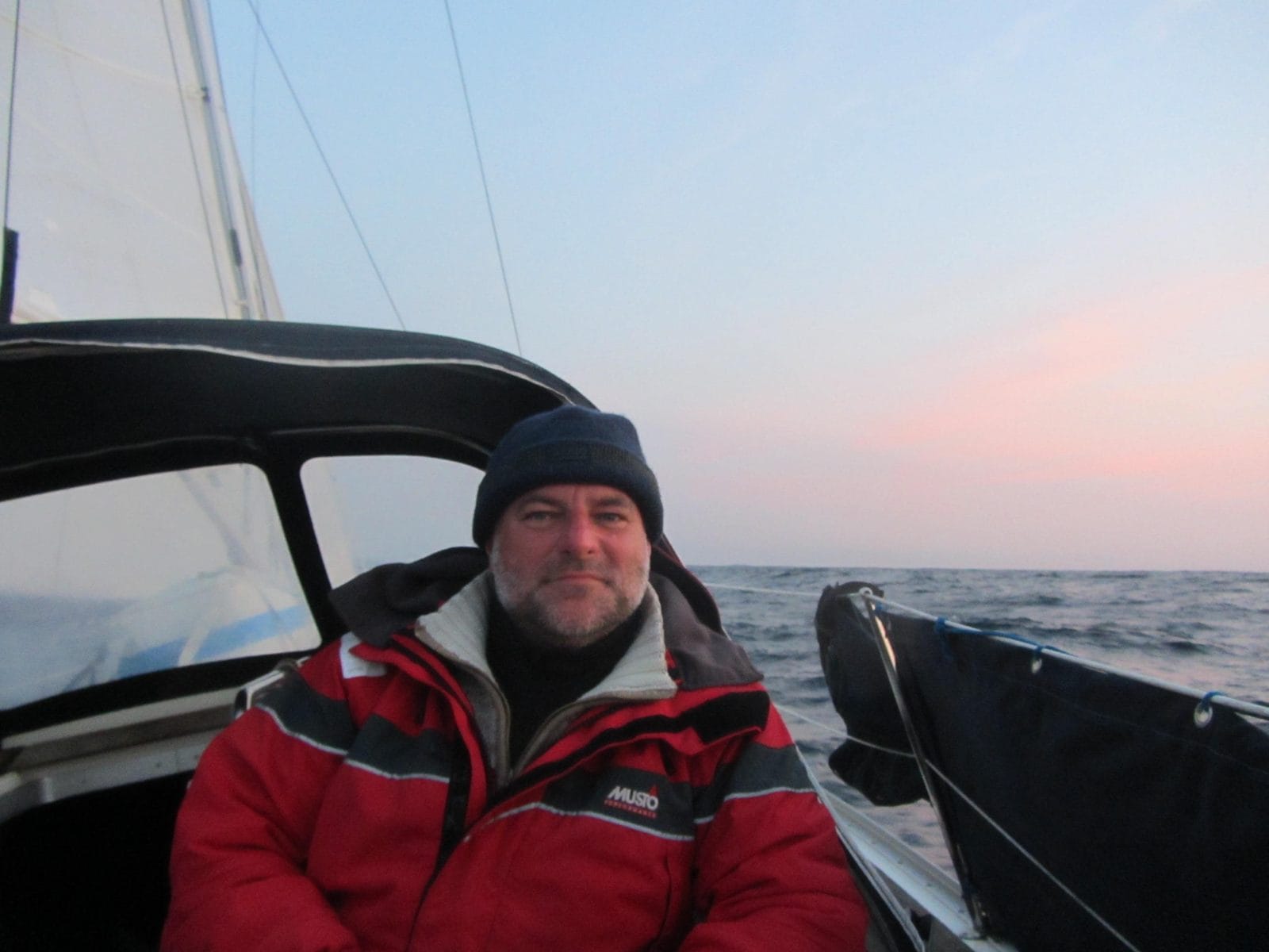 Crew member in foul weather gear at dawn on the Bavaria 31 yacht delivery