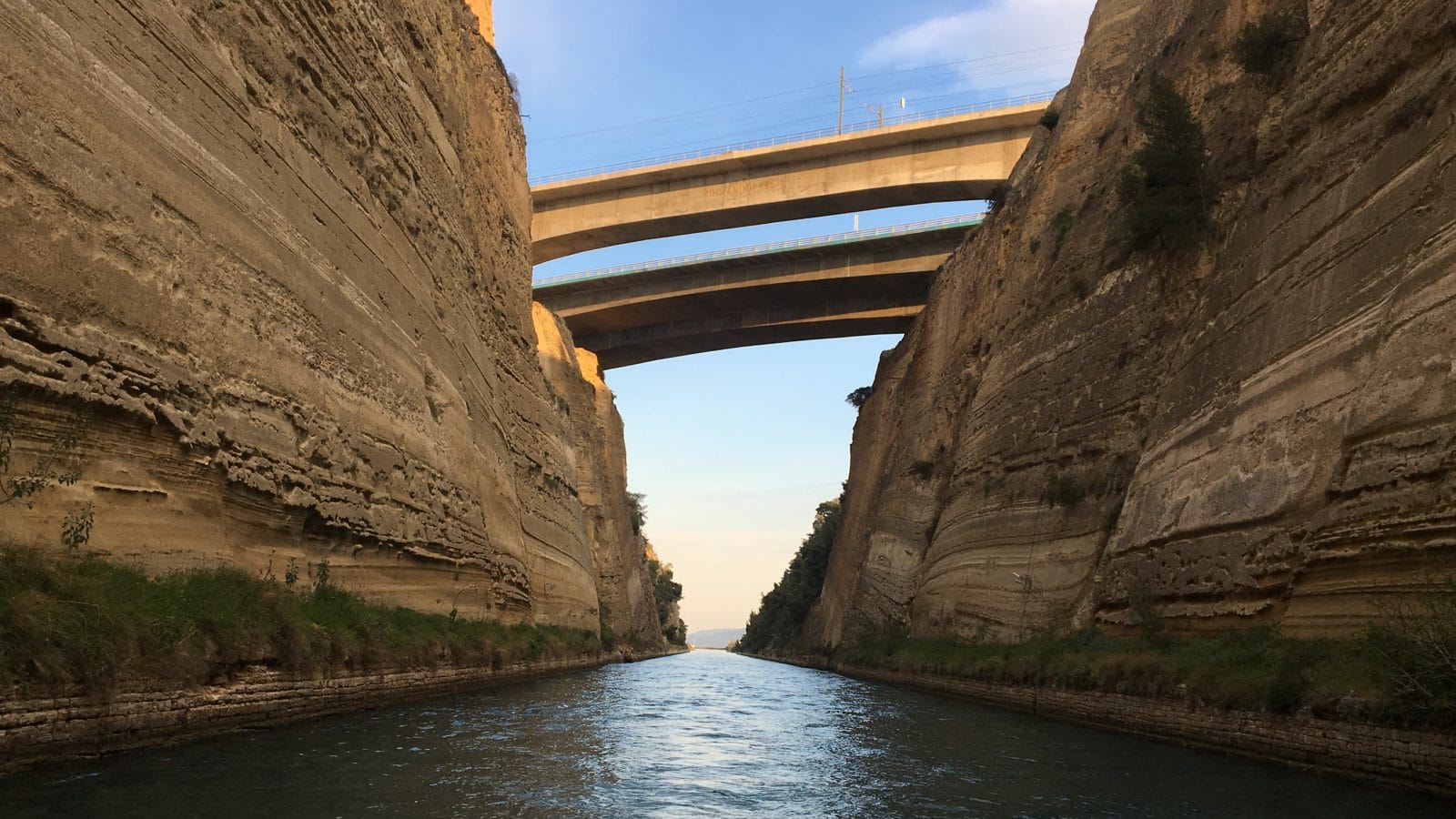 Road bridges high above the narrow Corinth Canal seen from the water, photographed on a Seven Seas yacht delivery in 2017