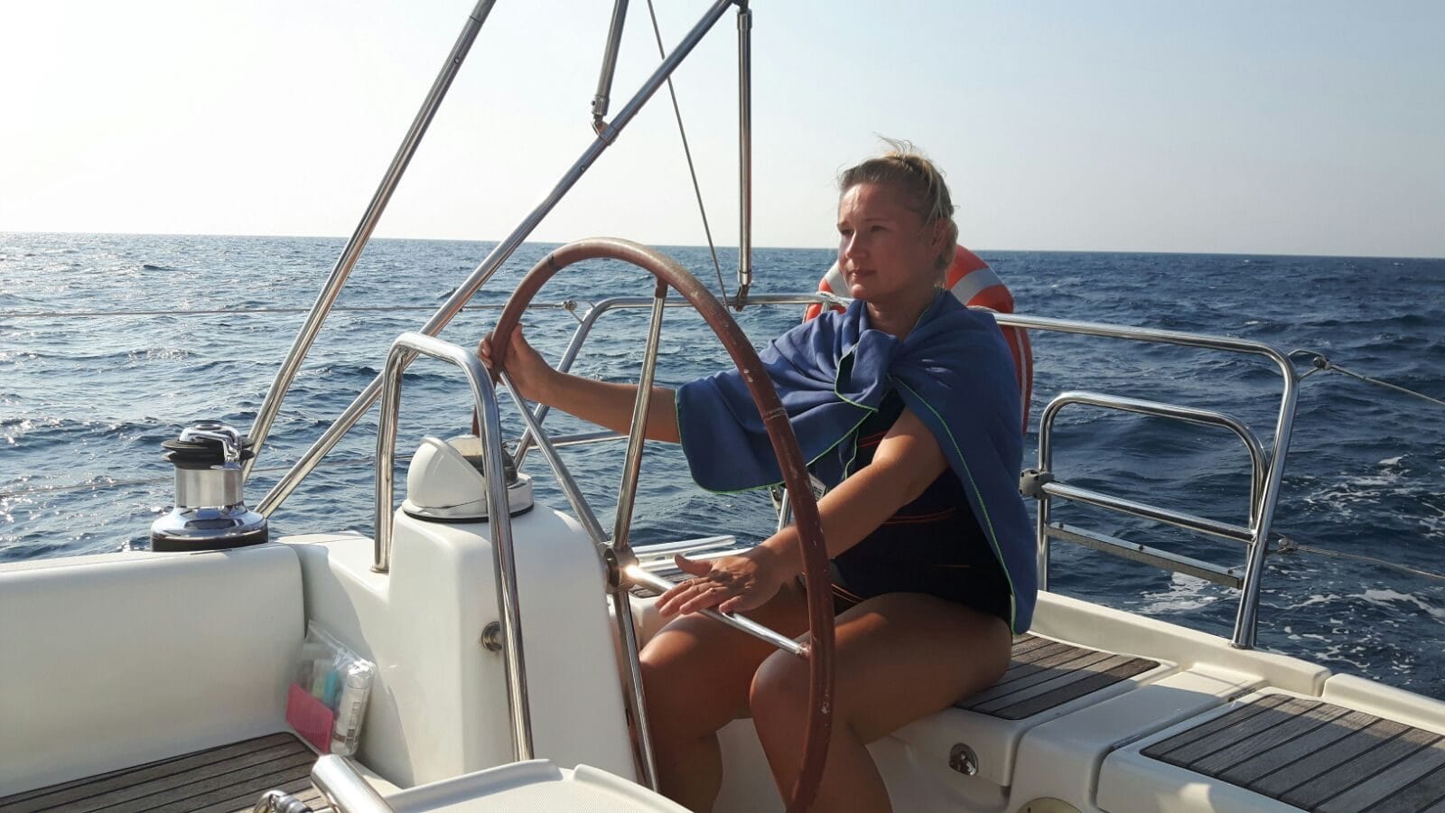 Crew member helming the Oceanis 40 on the Ionian Sea during the delivery to Lavrio