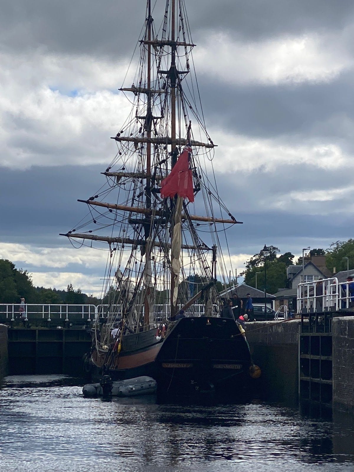 Tall ship Phoenix waiting in a Caledonian Canal lock with her red ensign flying