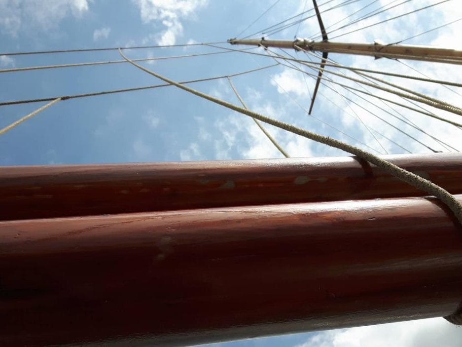 Wooden boom and rigging of the 1924 pilot cutter Tilikum against the sky